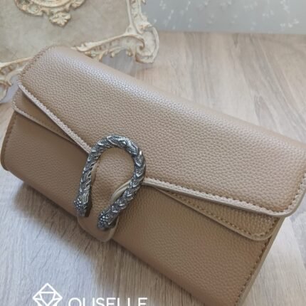 شنطة كتف نسائية جلد باللون الكافي بمقبض سلسلة فضية داكنة وقفل معدني مزخرف.